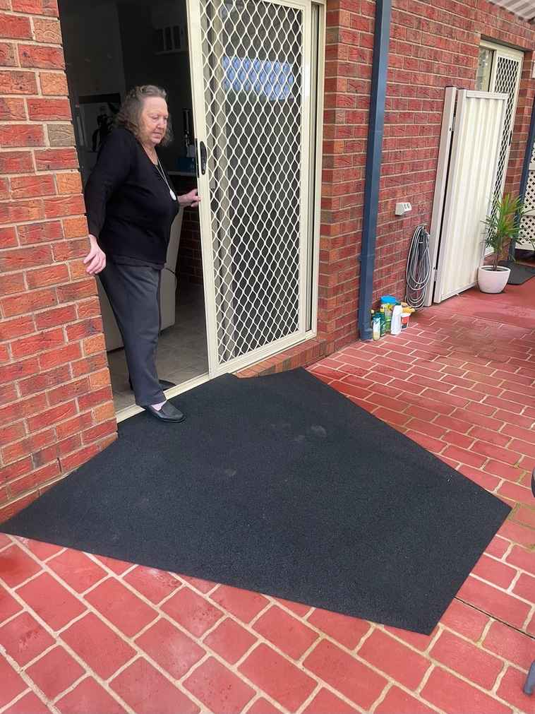 Customer with new rubber ramp Customer at her back door with a new rubber ramp on red brick pavers