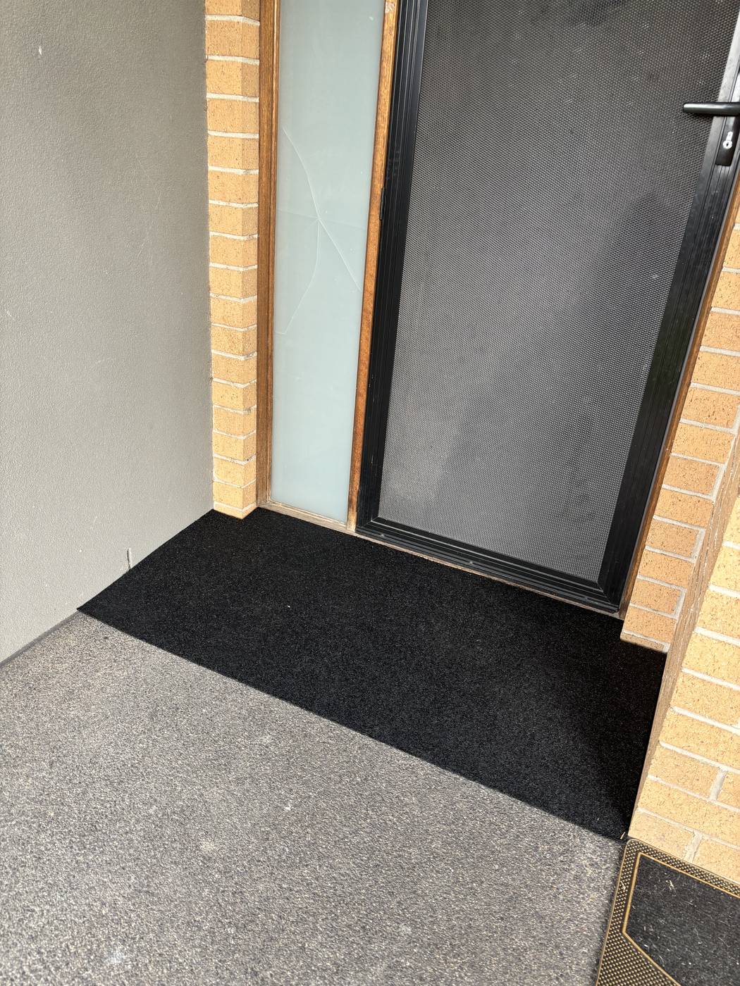 Rubber threshold ramp at an external door on a concrete landing