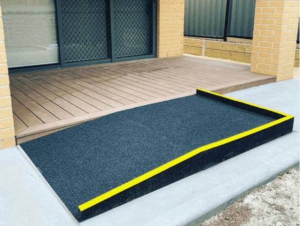 Recycled rubber access ramp with yellow safety edging leading onto a composite deck