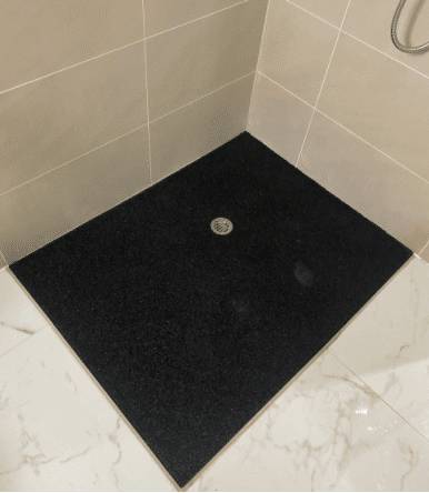 Rubber shower insert for bathroom mobility Custom-cut anti-slip rubber shower insert fitted to a tiled shower recess