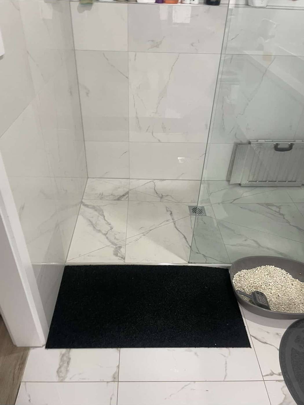 Rubber shower ramp Black rubber shower ramp in a marble-tiled walk-in shower