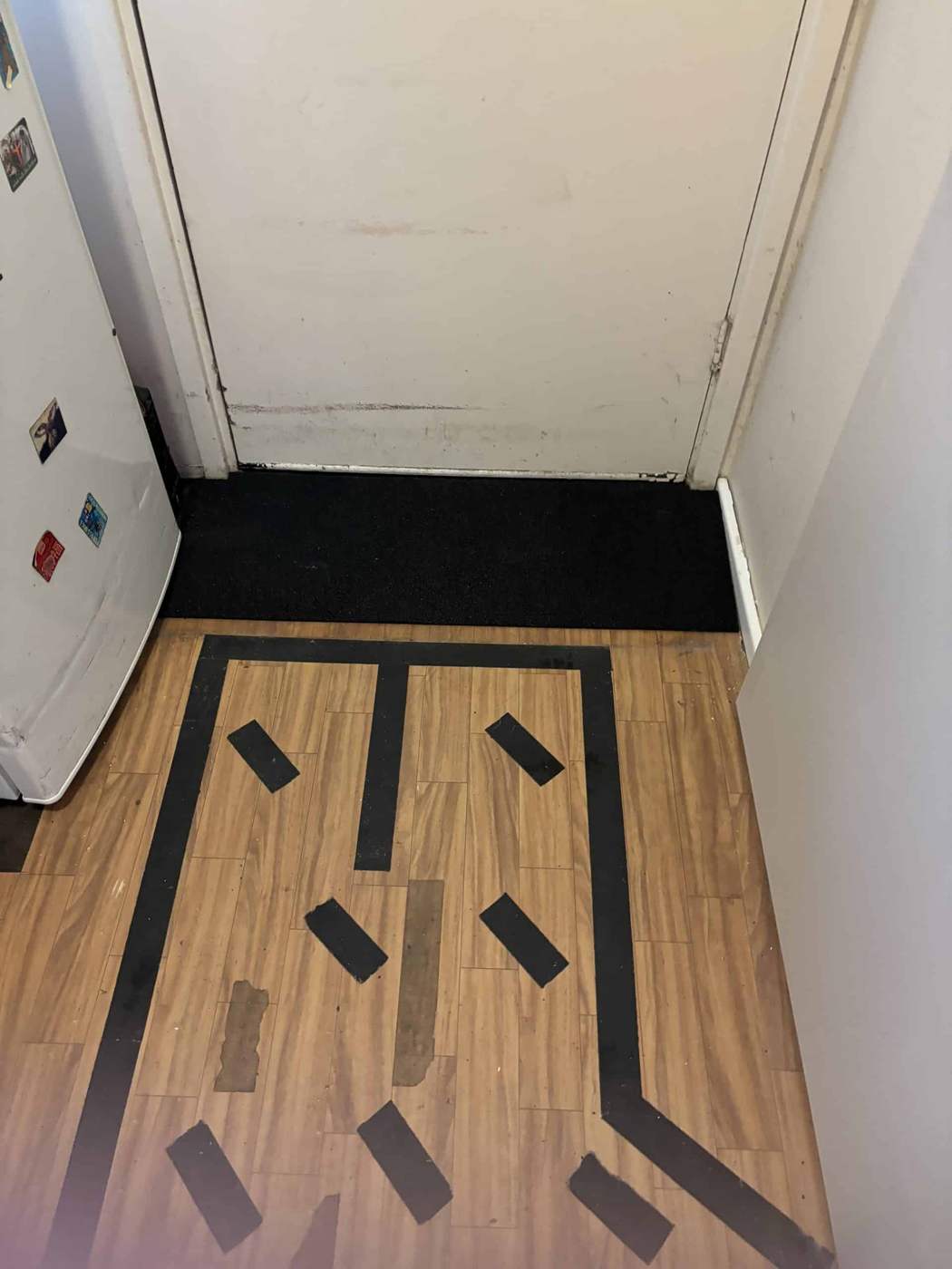 Laundry doorway threshold ramp Rubber threshold ramp at a laundry doorway with anti-slip strips on timber floor
