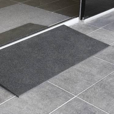 Rubber threshold ramp sitting against a sliding glass door track on tiles