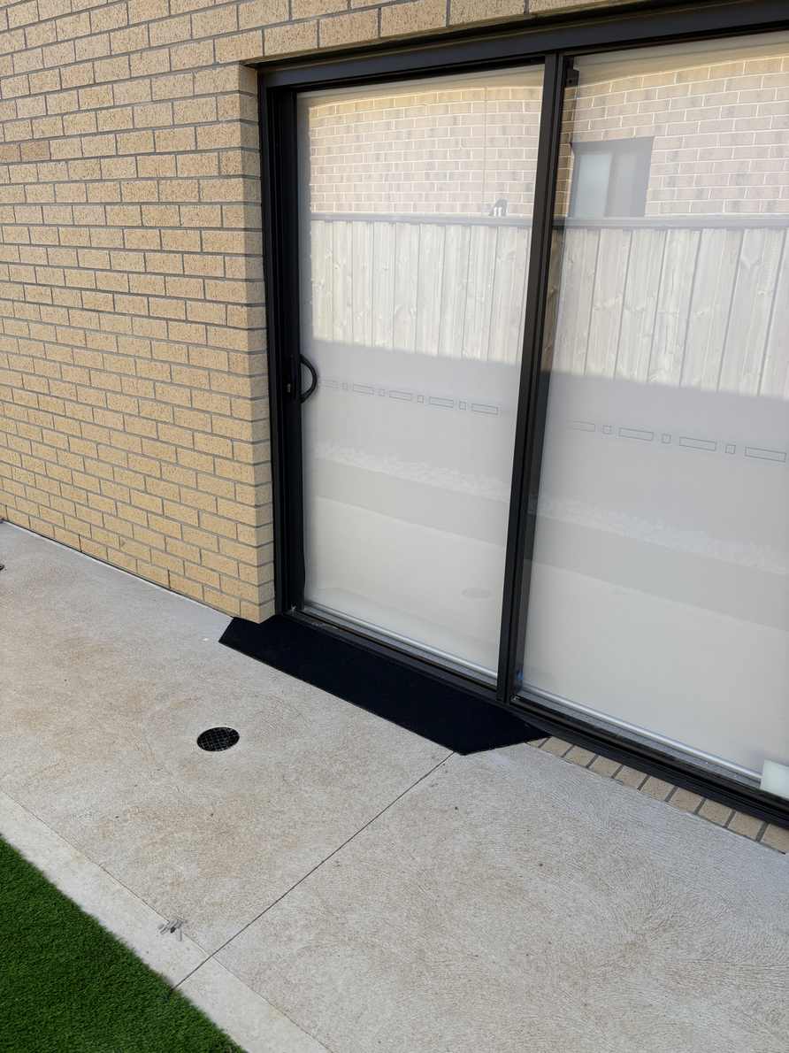Sliding glass door rubber ramp Low rubber ramp outside a sliding glass door onto a concrete path